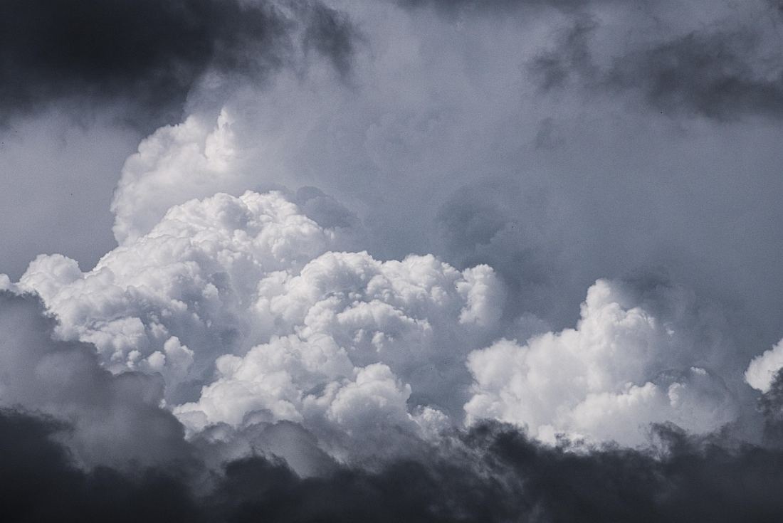 A wall of storm cloud building in a darkening sky.